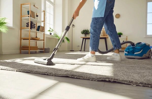 Carpet Cleaning technician in Raleigh - NC lifting soil from bedroom carpet with specialized extraction equipment