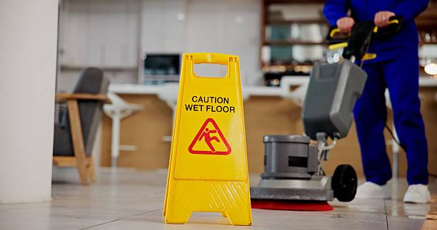 Professional cleaning technician using HEPA vacuum and sanitizing high-touch surfaces in modern Apex, NC workspace