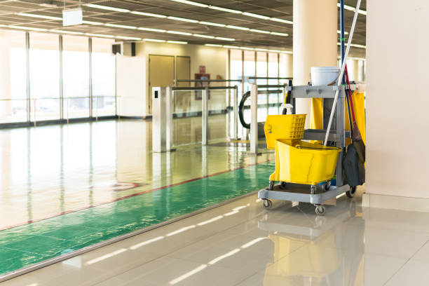 Cleaner mopping office hallway before staff arrive for the workday