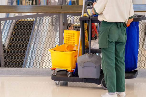 Experienced cleaner sanitizing office touchpoints with organized professional cleaning system