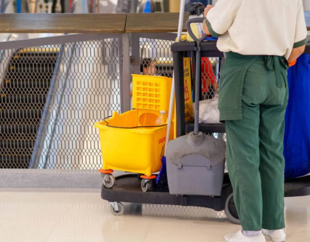 Experienced cleaner sanitizing office touchpoints with organized professional cleaning system